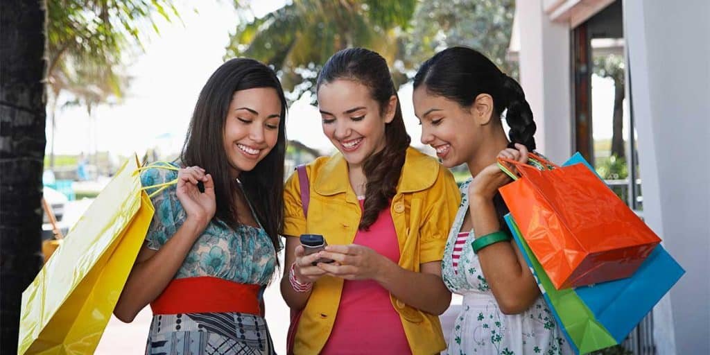 Girls on mobile phone looking for local business to shop at. Girls on mobile phone looking for local business to shop at.